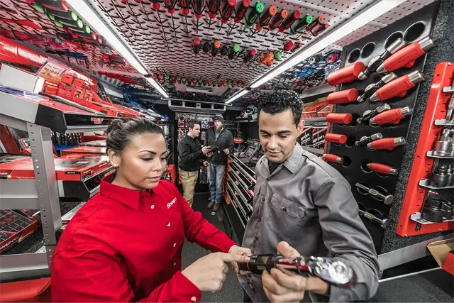 A man and woman browse tools together in a store, examining various items on display.