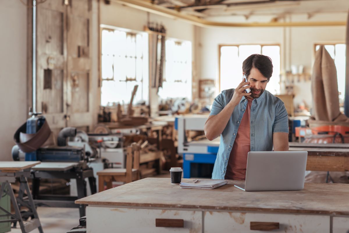 Man talking on a phone standing in his workshop