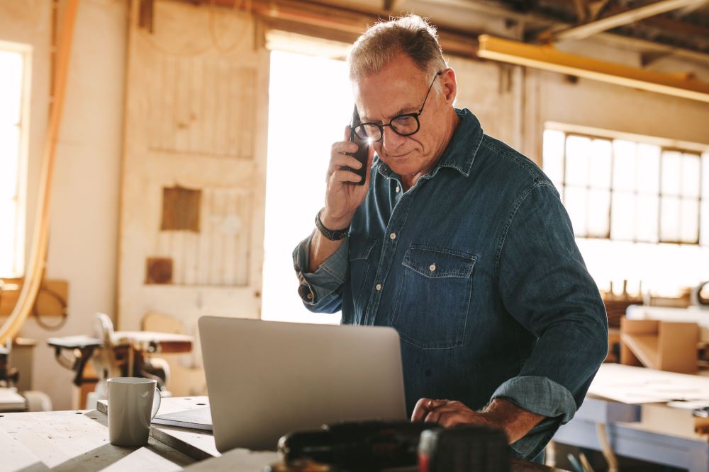 Business owner talking over the phone in his shop